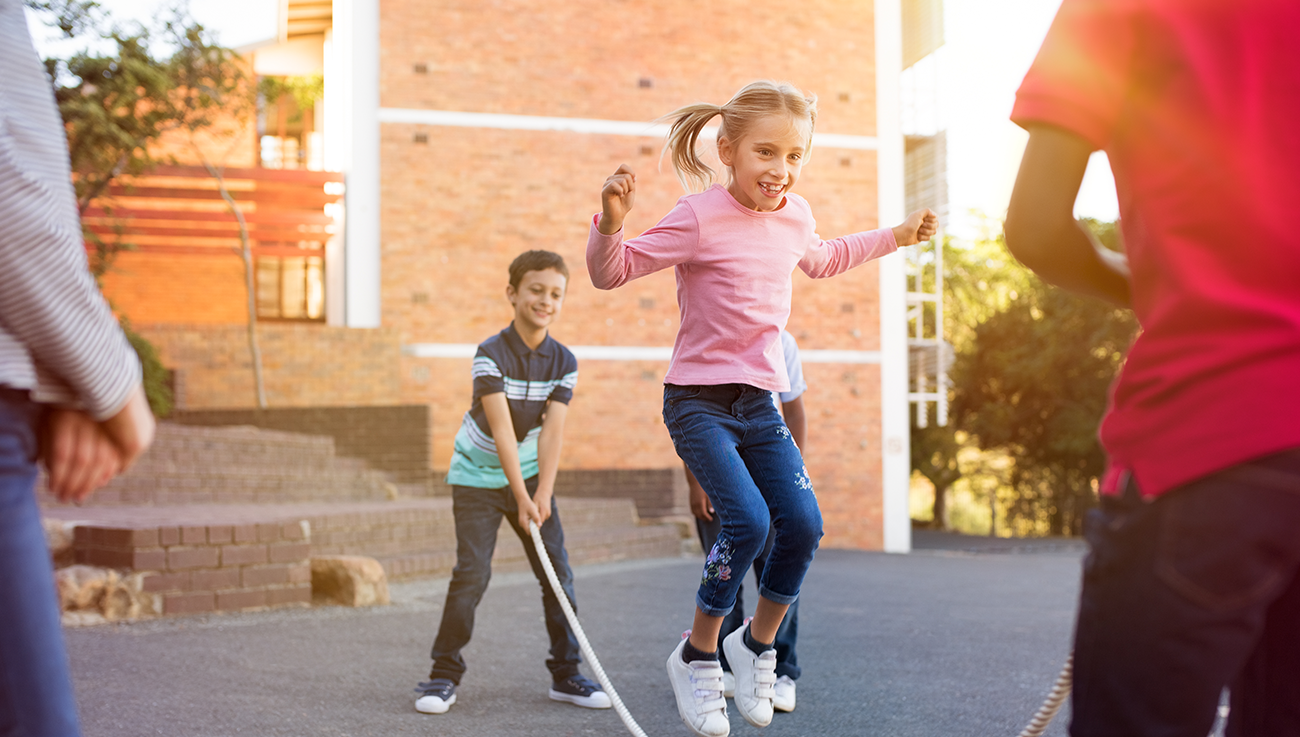 Children paying with a skipping rope on a playground