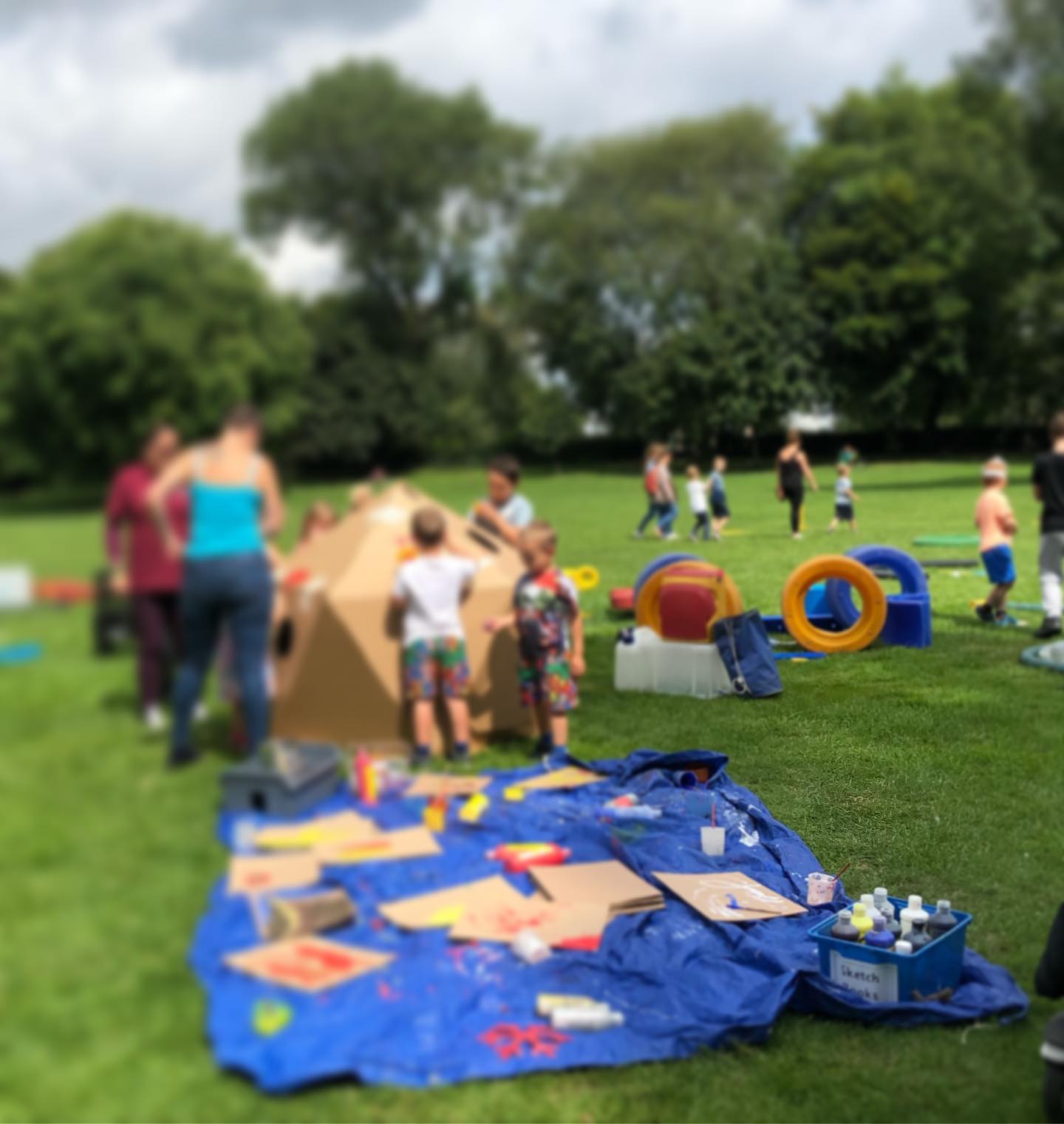 Children playing in a field with a variety of art materials